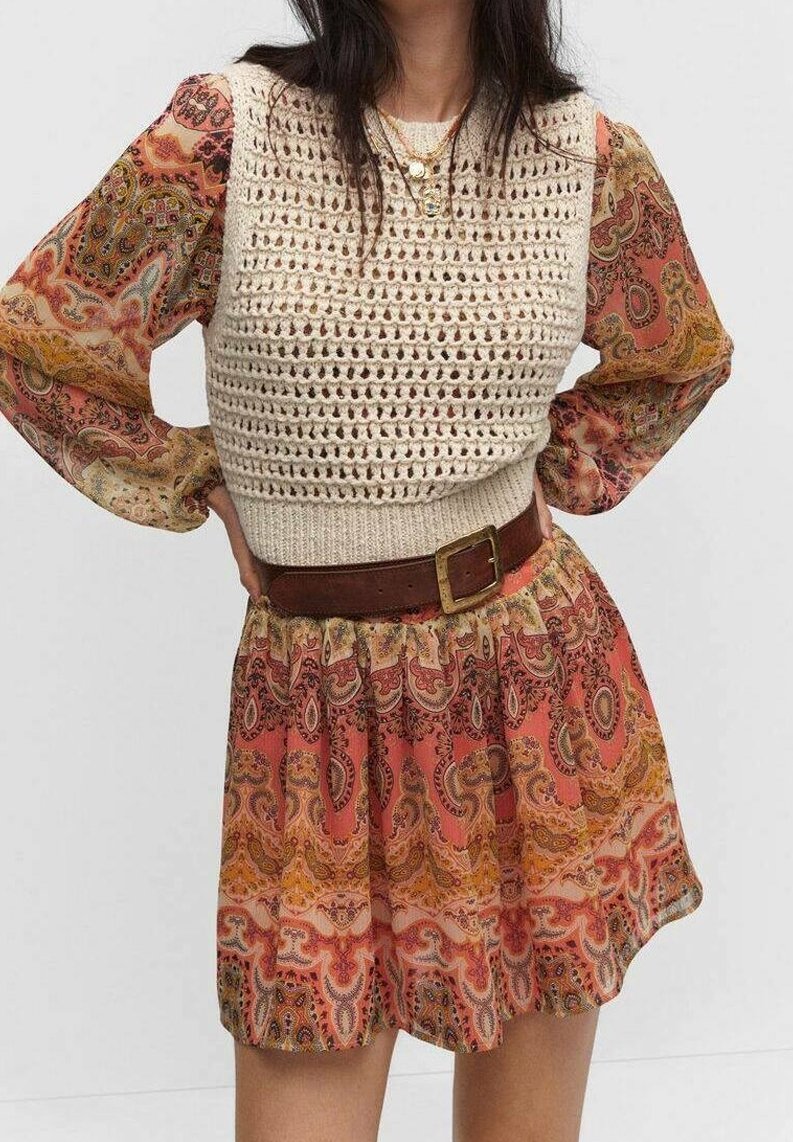 Kleid mit kurzen Ärmeln, oberteil aus cremefarbigem Häkelmaterial und gemustertem Rock in Pink, Orange und Braun, ausgestattet mit einem braunen Gürtel und strukturiertem Stoff.