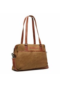 Sac fourre-tout en toile beige avec des anses et des accents en cuir marron, comportant une poche avant et des détails cousus pour une texture supplémentaire.
