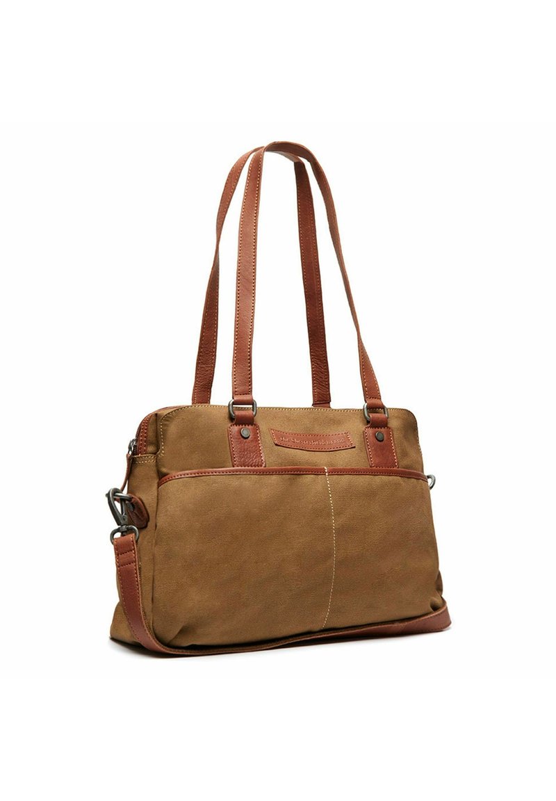Sac fourre-tout en toile beige avec des anses et des accents en cuir marron, comportant une poche avant et des détails cousus pour une texture supplémentaire.
