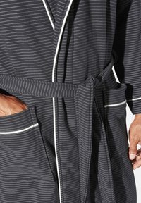 Gestreifter schwarzer Bademantel mit weißen Paspeln, ausgestattet mit Gürtel und Fronttaschen. Der Stoff wirkt weich mit einer glatten Textur.