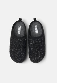 Pantofole nere in feltro con superficie texture e forma arrotondata. Presentano una soletta grigia con il marchio "CAMPER" e un tassello sul tallone.