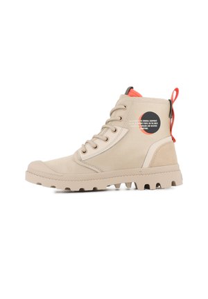 Bottines en toile beige avec une semelle en caoutchouc, bout rond, accents gris, tirette orange et logo sur le côté.