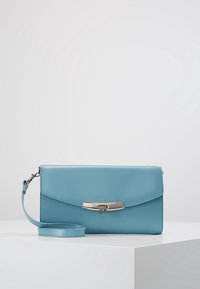 Blå läder crossbody-väska med en silverfärgad spänne, platt design och avtagbar rem. Har präglad logotyp och slät yta.