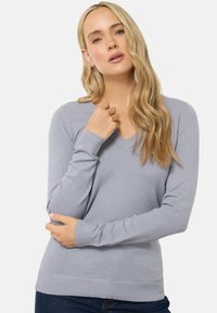 Lichtgrijze V-hals sweater gemaakt van zacht materiaal, met lange mouwen en een geribbelde zoom, met een getailleerd ontwerp dat de silhouet flatteert.