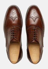 Scarpe da cerimonia in pelle marrone con dettagli brogue, punta tonda e design con lacci. Finitura liscia con texture e motivi a contrasto.