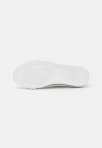 White sneaker sole featuring a textured design with herringbone pattern. Rounded toe and flat profile, designed for casual wear.