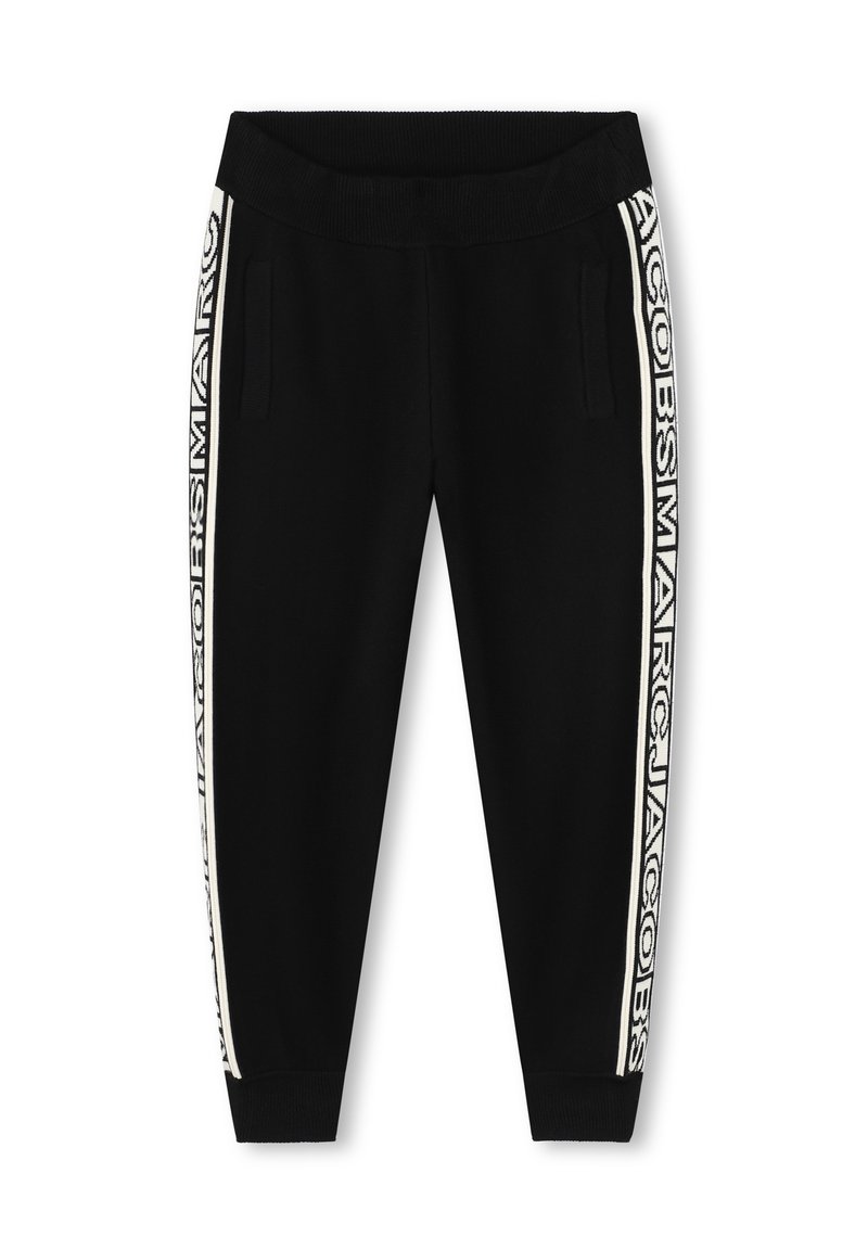Zwarte joggers gemaakt van zachte stof, met zijzakken en een geribde tailleband. Witte logotape loopt langs de buitenbenen.