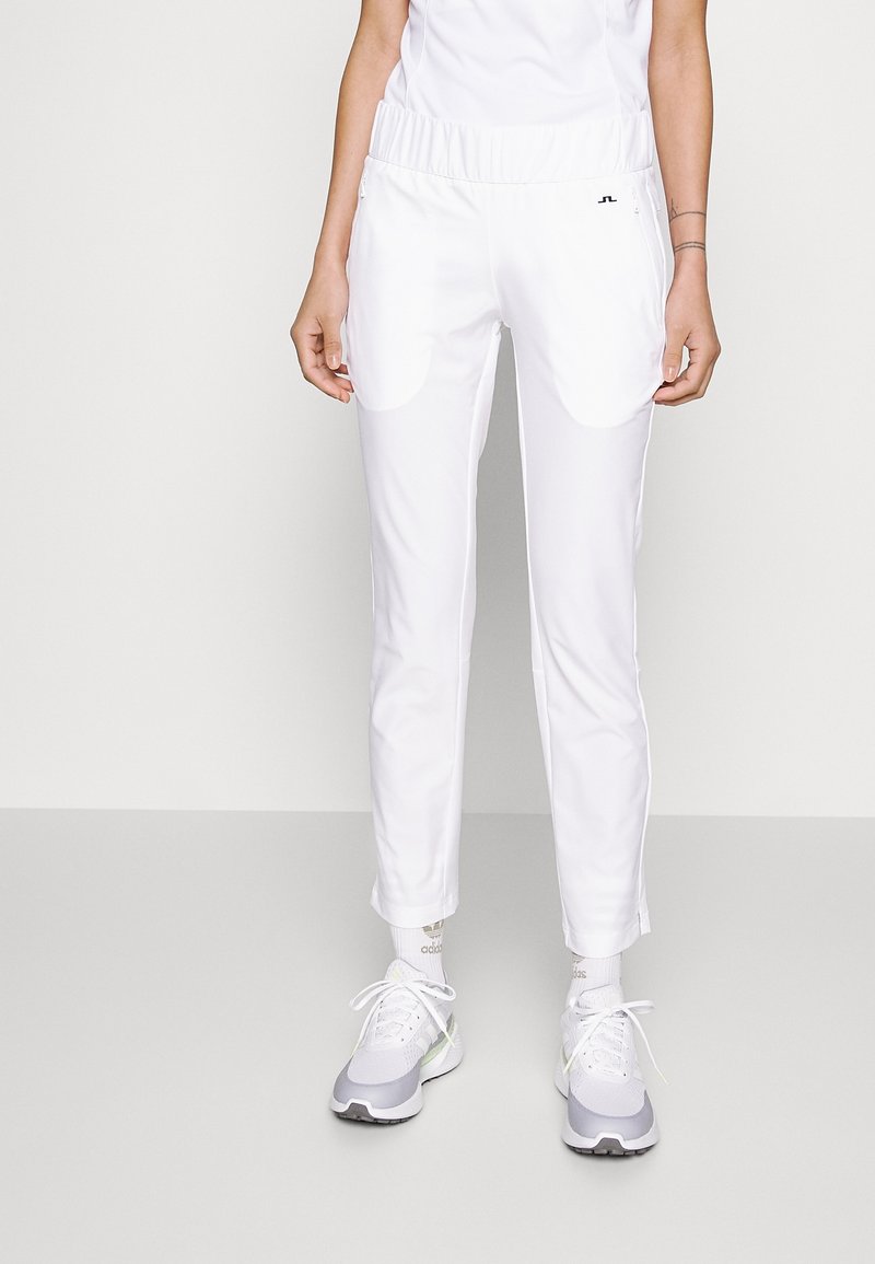 Vita sportiga byxor med elastisk midja, sidofickor och smal passform. Lättviktsmaterial med en mjuk textur.