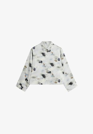 Rövidített gombos ing világosszürke szövetből, akvarell virágmintákkal kékkel, feketén és bézs színben. Klasszikus gallérral és hosszú ujjakkal rendelkezik.