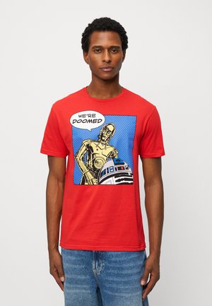 Man wearing red T-shirt with Star Wars characters C-3PO and R2-D2 in a comic style, speech bubble reads "We're doomed."