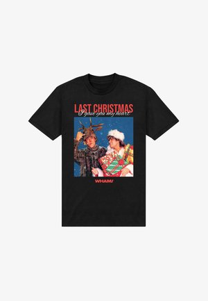 T-shirt nera in cotone con grafica natalizia vintage. Il testo recita "LO SCORSO NATALE ti ho dato il mio cuore." Il design include uno sfondo colorato con carta da regalo.