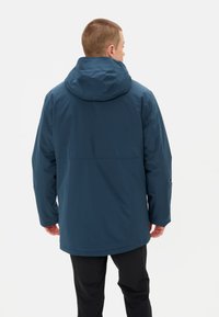 Giacca impermeabile da uomo di colore blu scuro, con cappuccio, maniche lunghe e taglio dritto. Realizzata in tessuto liscio e leggero.