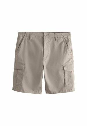 Bēšas kravas šorti ar sānu kabatām ar atloku, priekšējām slīpajām kabatām, jostas cilpām un pogu aizdari uz vienmērīgas baltas virsmas.