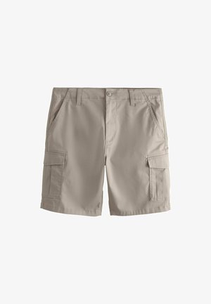Beige cargo shorts with side flap pockets, front slant pockets, belt loops, and a button closure on a plain white background.