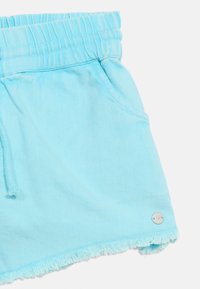 Ανοιχτό μπλε βαμβακερά σορτς με ελαστική μέση, τσέπες, κορδόνι, κρόσια στο τελείωμα και μικρό στρογγυλό μεταλλικό λογότυπο της μάρκας στο μπροστινό κάτω άκρο.