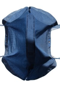 Duża, otwarta torba tote z głęboko niebieskim, fakturowanym wykończeniem wnętrza, gładkimi skórzanymi akcentami i zapięciem na klapę. Wnętrze charakteryzuje się minimalistycznym wzornictwem.