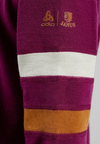 Maroon knit fabric with white and orange horizontal striped accents on the sleeve; features gold logos of Odlo and Janus.