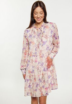 Blumenkleid in hellem Beige mit lila und orangefarbenen Mustern, das einen gebundenen Kragen, lange Ärmel und einen gestuften Rüschensaum hat. Halbtransparente Stoffqualität.