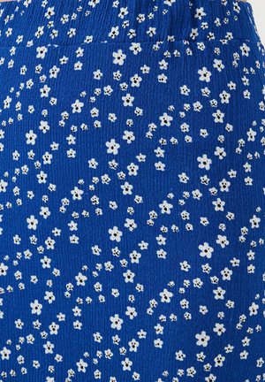 Blue fabric with a textured surface featuring scattered white flowers and black dot centers, creating a floral pattern across the material.