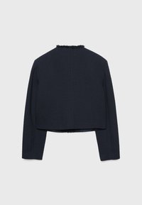 Veste bleu marine texturée à manches longues et coupe courte. Dotée d'accents effilochés le long du col. Vue de dos uniquement.