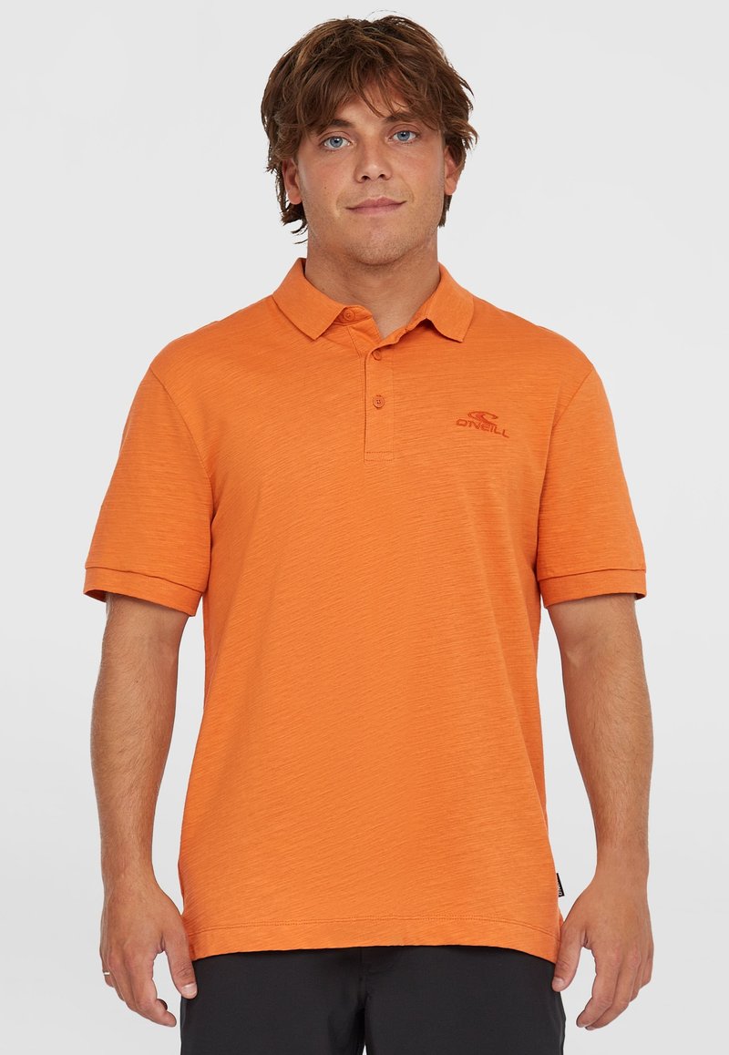 Polo tričko s krátkym rukávom v jasne oranžovej farbe, vyrobené z texturovanej tkaniny. Obsahuje klasický golier a vyšívané logo na hrudi.