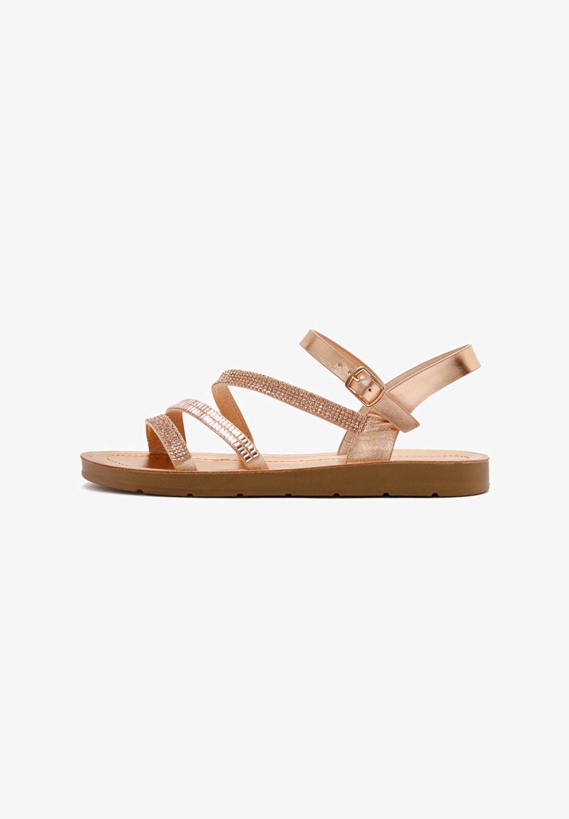 Roze gouden sandalen met verstelbare banden en een platte zool, voorzien van gestructureerde banden en een gesp. Gladde afwerking en gevoerde binnenzool voor comfort.