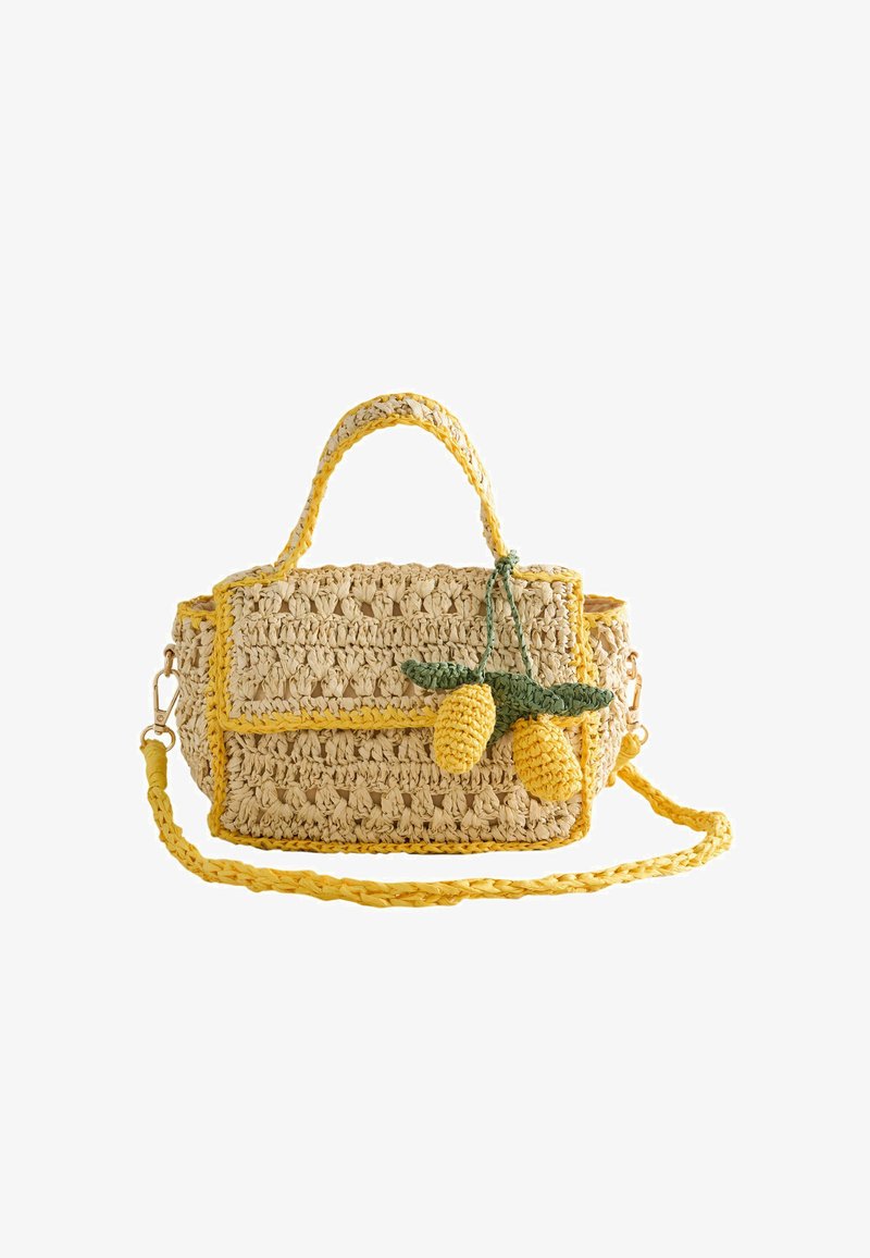 Petit sac à main beige en crochet avec bordure jaune, deux décorations au crochet en forme de citron, anse supérieure et longue bandoulière tressée.