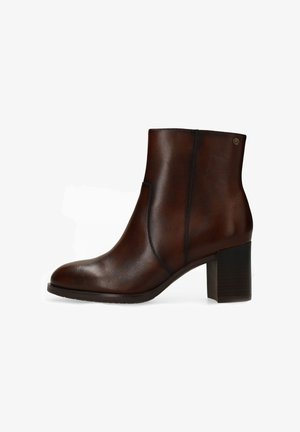 Bottine en cuir marron avec un bout arrondi, un détail élastique sur le côté et un talon carré de 7,5 cm. Texture lisse et ornementation minimale.