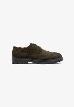 Donkergroene suede veterschoenen met geperforeerde details, ronde neus en zwarte rubberen zool. Beschikt over vetersluiting voor een veilige pasvorm.