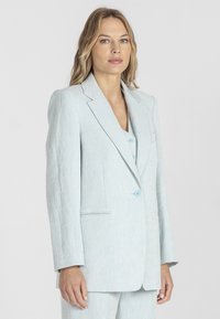 Jasnoniebieska lniana marynarka o strukturalnym designie, z zapięciem na jeden guzik, klapami i bocznymi kieszeniami, zapewniająca dopasowany krój.