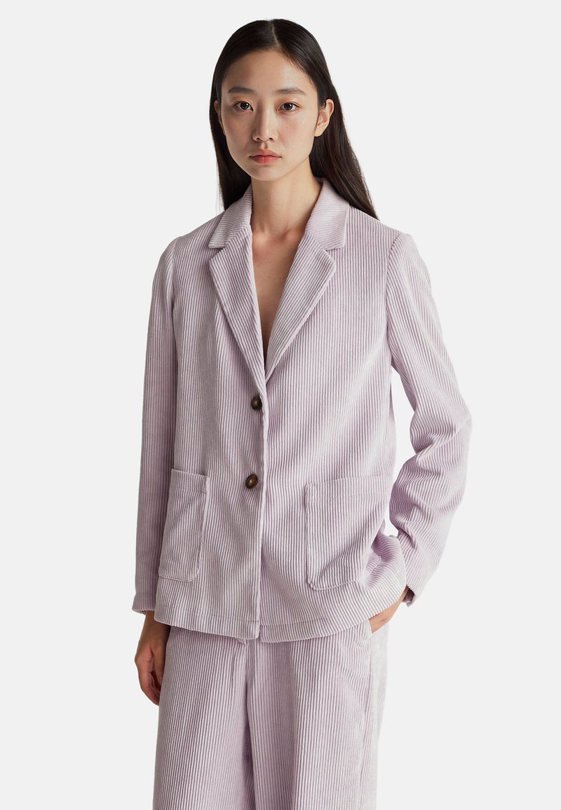 Blazer de pana de color lilac claro con solapa muesca, dos bolsillos frontales y cierre de un solo botón; acompañado de pantalones a juego.