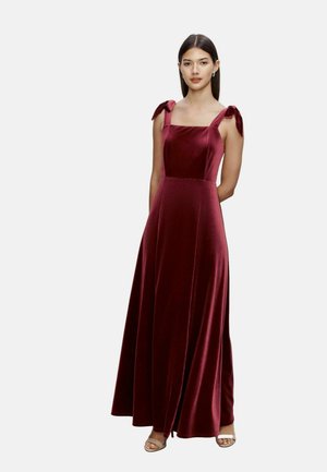 Rochie maxi din catifea bordeaux cu decolteu pătrat, fundițe pe umeri și o fustă fluidă. Textură netedă cu un strălucire subtilă.