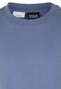 Modrá bavlnená tričko s krátkym rukávom a rebrovaným výstrihom. Na štítku je uvedené "Urban Classics" a sú zahrnuté pokyny na údržbu.