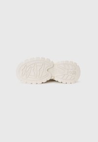 Talpa sneaker de culoare off-white, cu striații și caneluri texturate, având un logo proeminent și un finisaj neted. Proiectată pentru aderență și durabilitate.