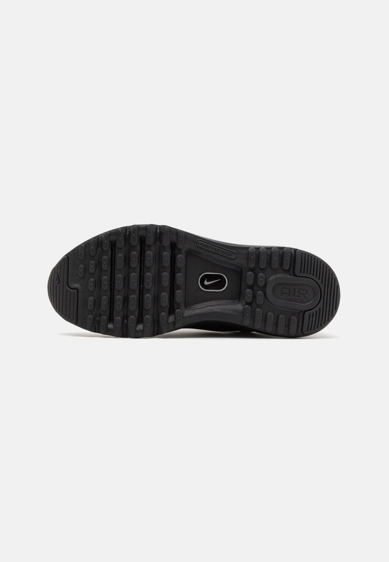 Semelle noire en Nike Air avec du caoutchouc texturé, présentant des boutons ronds pour l'adhérence et une section centrale lisse avec des détails de logo.