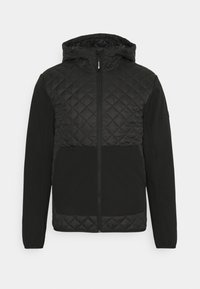 Svart jacka med quiltat ovre avsnitt och solidt nedre avsnitt. Har dragkedja och en huva med justerbara knutar.