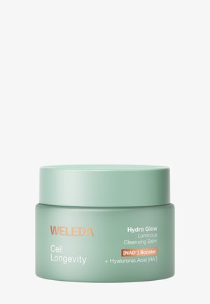 Pot de baume nettoyant lumineux Weleda Cell Longevity Hydra Glow avec booster de NAD+ et acide hyaluronique dans un emballage vert.