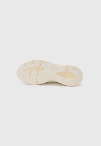 Sohle eines Sneakers, mit einer strukturierten GummOberfläche in heller Cremefarbe und geometrischen Mustern für Traktion und Unterstützung.