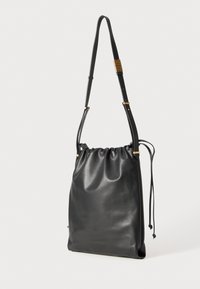 Črna usnjena torba na vlečenje z gladko teksturo, nastavljivim naramnikom in zlatimi detajli; minimalističen dizajn.