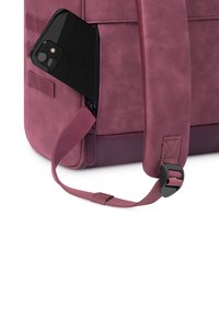 Borsa in ecopelle viola con forma strutturata, dotata di una tasca laterale con zip contenente uno smartphone nero. Include una tracolla regolabile.