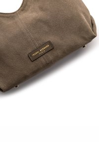 Braune Wildleder-Handtasche mit einem goldenen geprägt Logo, weicher, geschwungener Form und dezenten Nähten. Mit Metallbeschlägen akzentuiert.