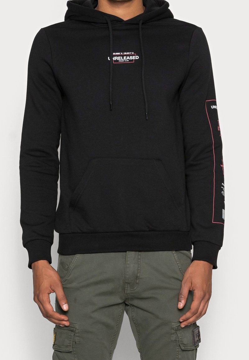 Felpa nera in cotone con tasca frontale e cappuccio con cordoncino. Presenta testo bianco e rosa sul petto e sulla manica. Polsini e orlo a coste.