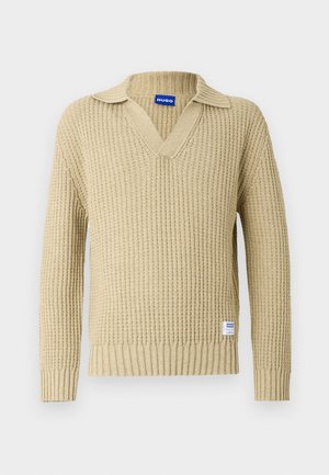 Pulover bej tricotat, cu decolteu în V și textură reiată. Prezintă un guler pliat. Include o etichetă mică a brandului în partea stângă jos.