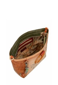 Braune Lederhandtasche mit dekorativen Metallnieten und Anhängern, grünem Innenfutter, Reißverschlusstasche und Details am Holzgriff.