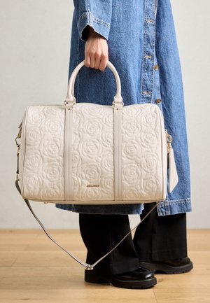 Sac en cuir blanc matelassé avec des motifs de roses, poignées doubles, bandoulière amovible et accents dorés. Forme rectangulaire avec une surface texturée.