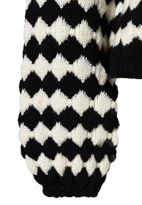 Strickärmel eines Pullovers mit einem schwarz-weißen Rautenmuster, strukturiertem Stoff und gerippter Manschette, der geometrische Designelemente betont.