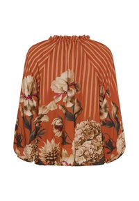 Blomsterblusen har en orange baggrund med hvide og brune blomsterprints, lodrette striber og en samlet halsudskæring.