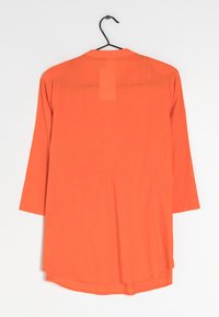 Blusa arancione con maniche a tre quarti, colletto standard, tessuto leggero e orlo leggermente arrotondato. Etichetta cucita sul retro.