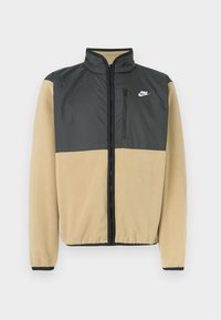 Fleece bunda Nike s rozděleným designem, s horní částí v tmavě šedé barvě a spodní částí v béžové, s kapsou na zip a vysokým límcem.