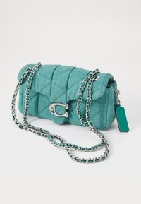 Quilted teal fabric handbag with silver chain strap, a clasp closure, and a tag attached. Compact rectangular shape with detailed stitching.